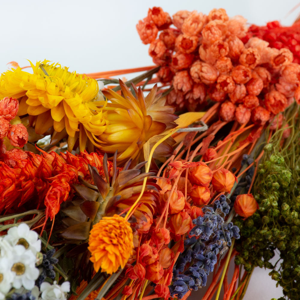 a bouquet made up with a selection of different flowers with an orange theme