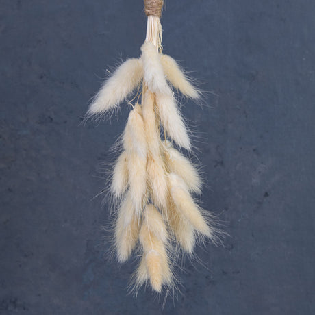 A close up of a bleached White lagurus formed into a little hanging decoration.