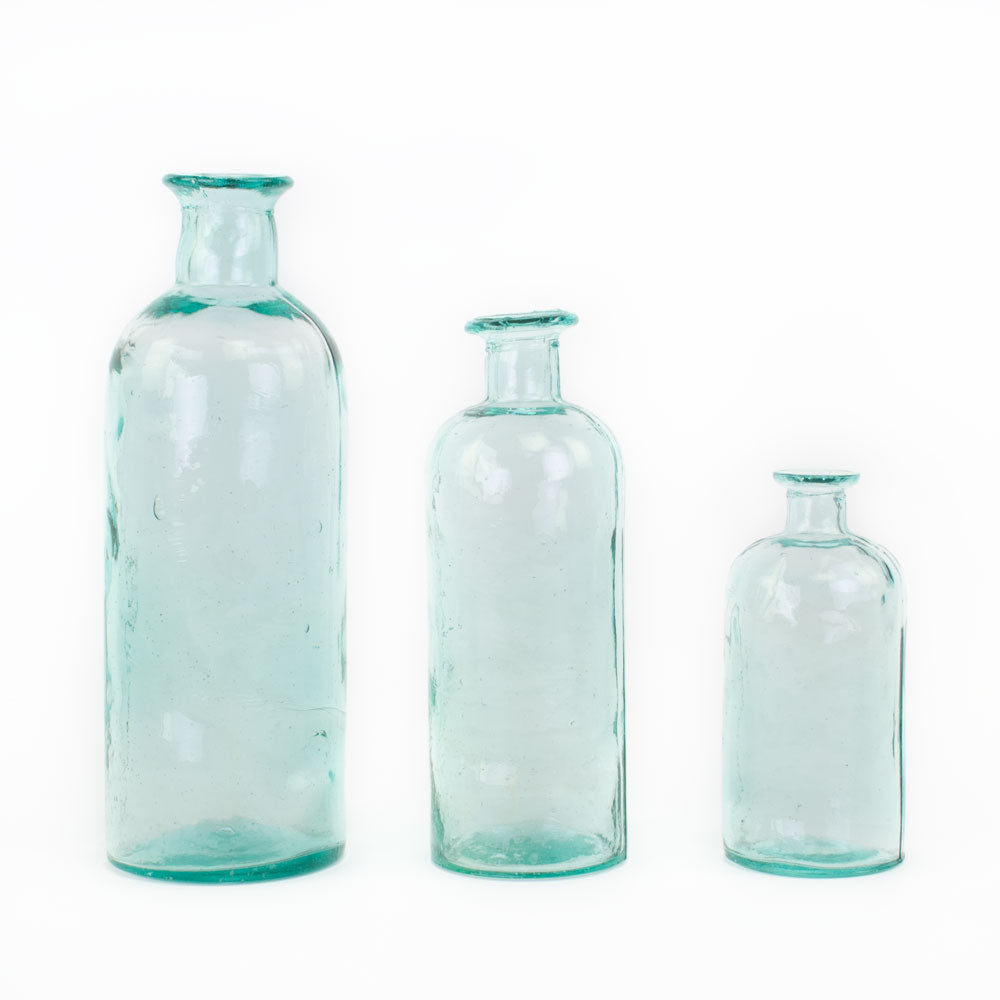 a group of three Waimaru blue/green glass bottles in different sizes