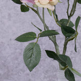 A close up of the leaf detail on a faux pink rose spray