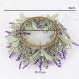 An artificial floral wreath made up of lavender flowers and silvery-green leafy foliage