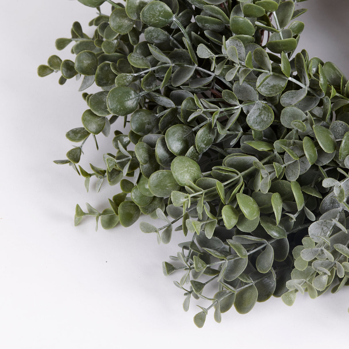Close up image of the stems of artificial Eucalyptus Baby Blue Sprigs made into a wreath.
