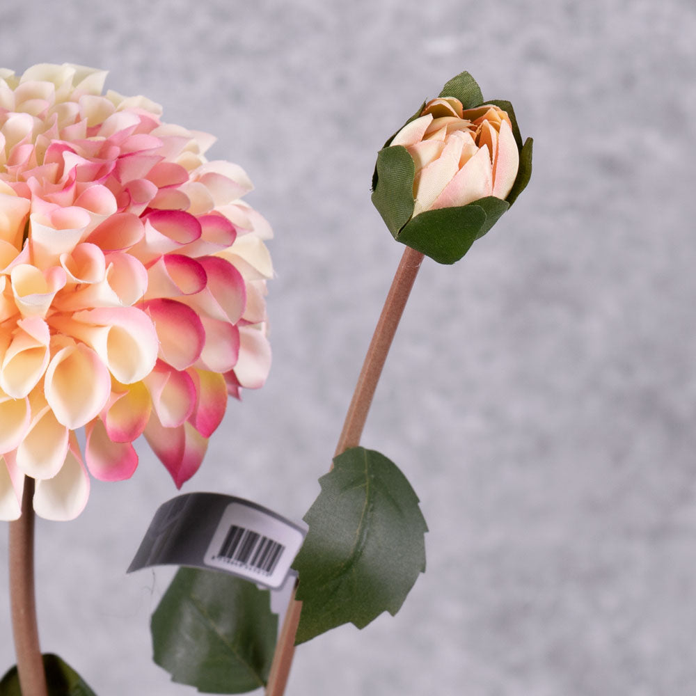 A faux cream and pink dahlia spray showing a full bloom and focusing on an emerging bud