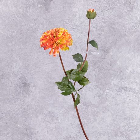 A faux dahlia spray with a flower in a rich orange-red colour, and a bud on another shoot