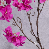 A close up of bright pink flowers on a faux Bougainvillea stem