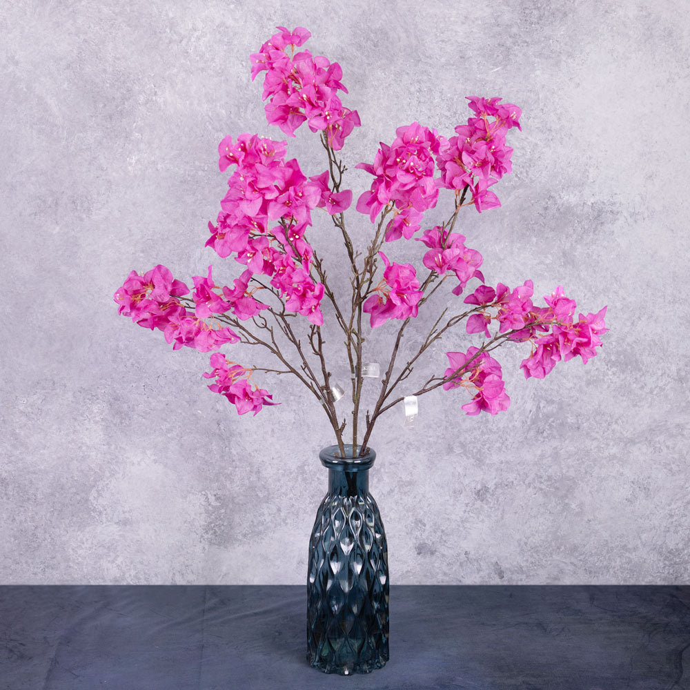 Three faux Bougainvillea sprays with bright pink flowers over multiple branchlets, displayed in a blue glass vase