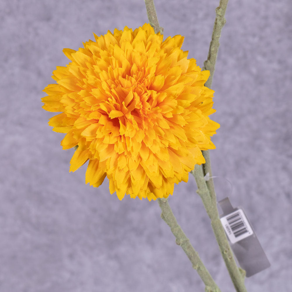 A close up of a single faux sunflower in rich yellow