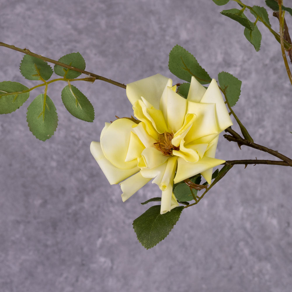 A close up of a faux yellow rose flower