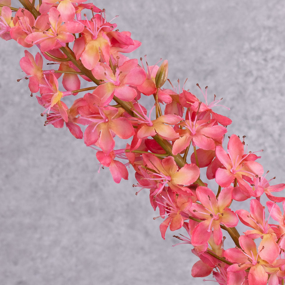 A close up shot of a faux foxtail lily with warm pink flowers