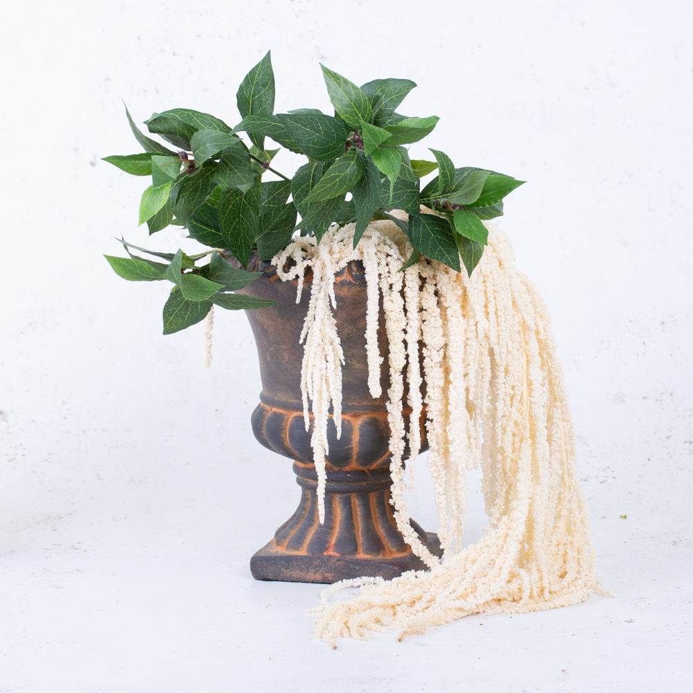 Bleached white amaranthus displayed in a rustic urn with some faux bay leaf stems.