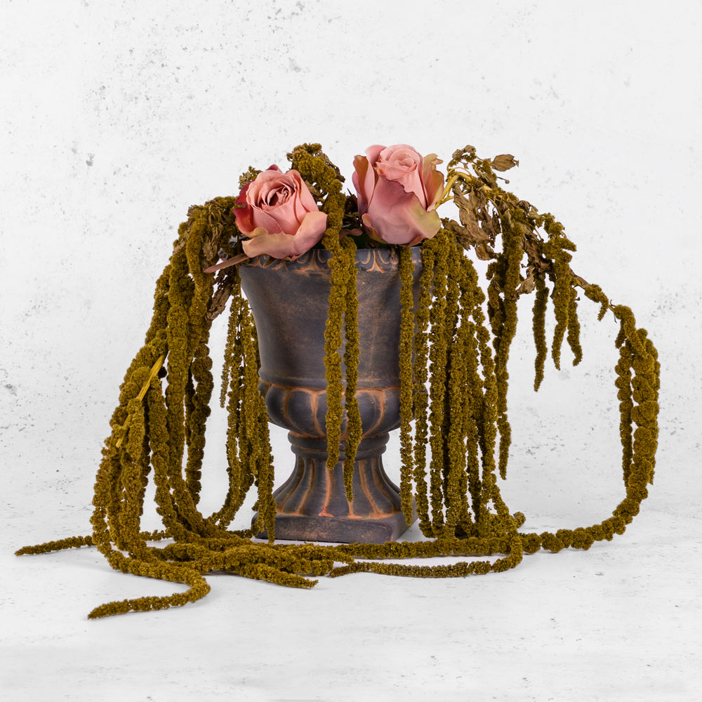Almond green amaranthus displayed in a rustic urn with faux roses.