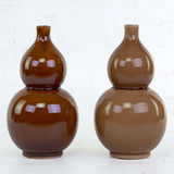 A pair of brown and coffee coloured vases