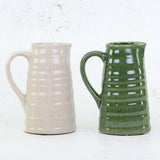 A pair of ceramic jugs in green and cream