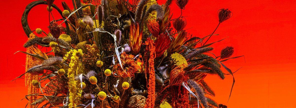 a large bouquet of different flowers on an orange background