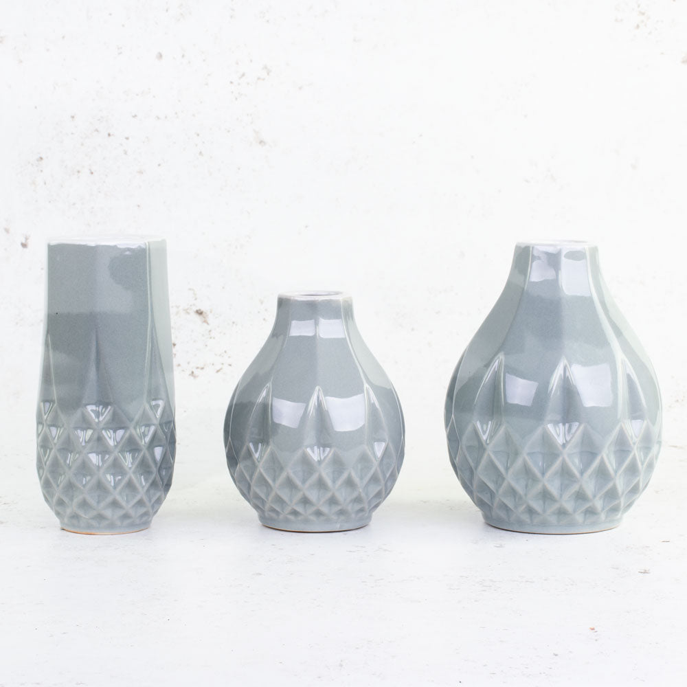 A set of three different styles of vase in a blue grey colour