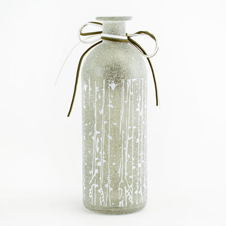 This image shows a pale green, frosted glass vase, with a small wooden star tied around its neck, against a white background