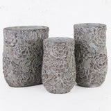 A group of 3 similarly flower patterned stone vases.