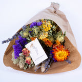 This image shows a pre-made wildflower bouquet, contain a mix of flowers with orange hues.