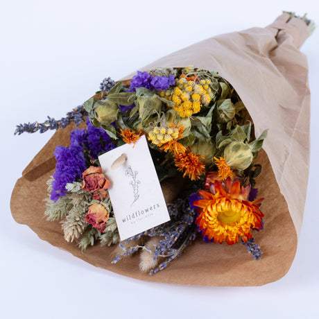 This image shows a pre-made wildflower bouquet, contain a mix of flowers with orange hues.