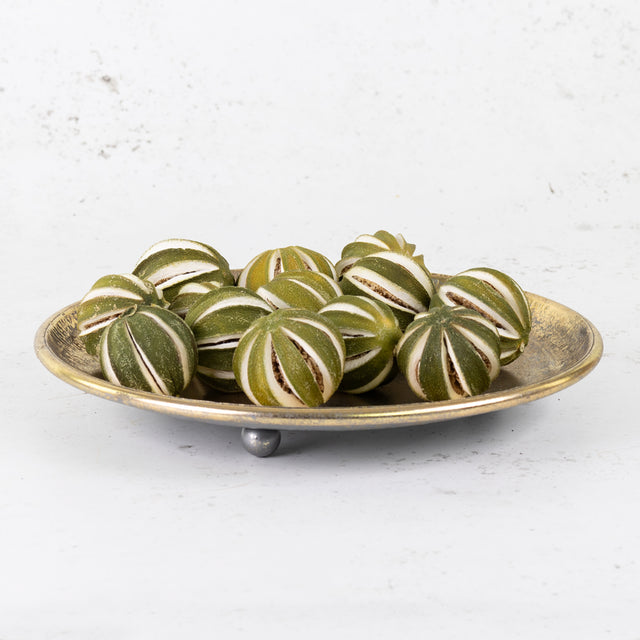 A group of scored, whole oranges in their un-ripened green colour/