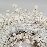 a wreath made of linen herb and painted a chalky white colour, against a white background