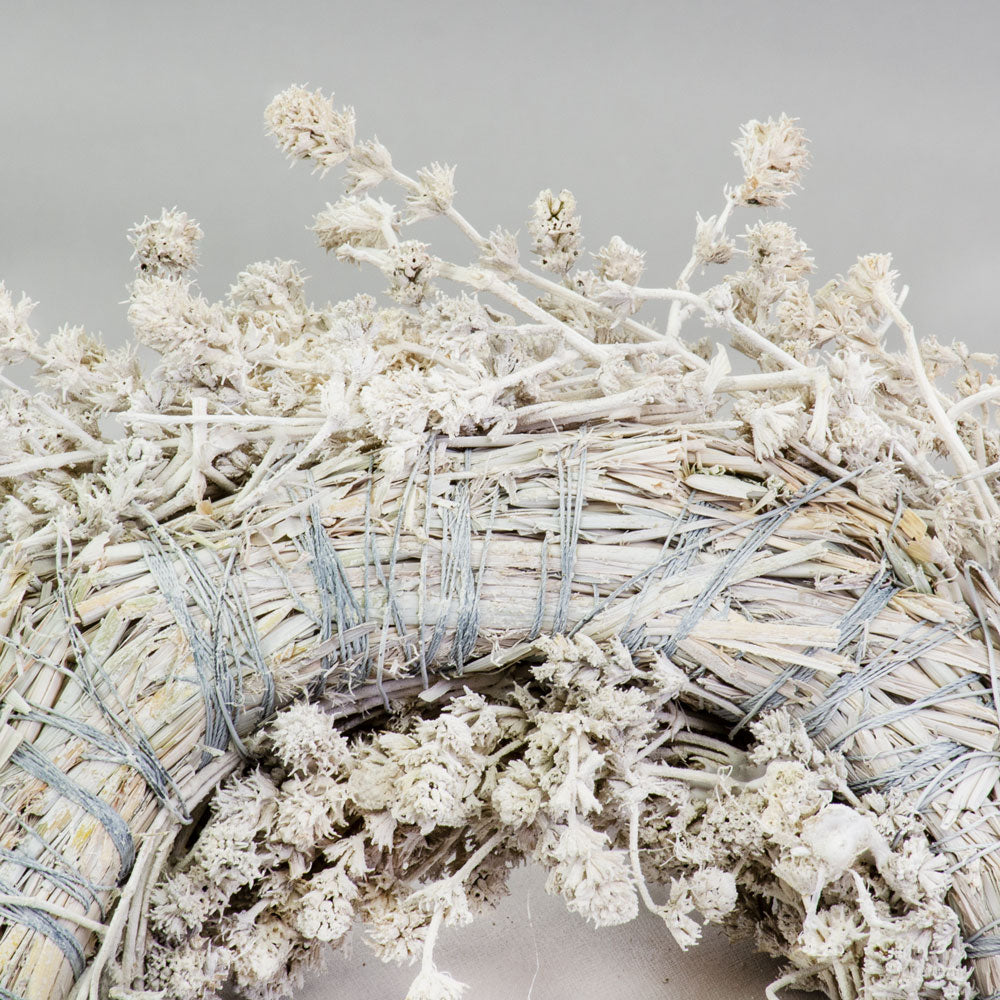 a wreath made of linen herb and painted a chalky white colour, against a white background