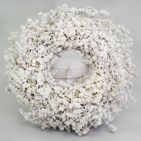 a wreath made of linen herb and painted a chalky white colour, against a white background