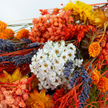 a bouquet made up with a selection of different flowers with an orange theme