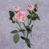 A faux pink rose spray shown in a frosted white glass vase