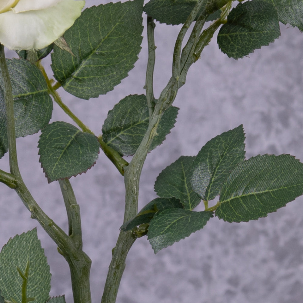 A close up of the leaf detail on a faux white rose spray