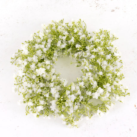 An artificial gypsophila wreath with white flowers, on a green plastic frame.