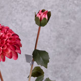 A faux deep pink dahlia spray showing a full bloom and focusing on an emerging bud
