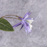 A close up of a pair of faux aquilegia flowers in a lavender hue with a white centre,