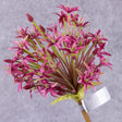 A close up of a single faux allium stem with deep pink coloured flower plume