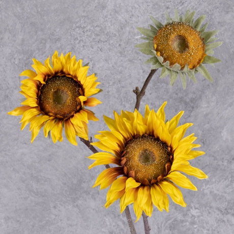 A faux sunflower spray in a rich yellow colour., showing three flowers