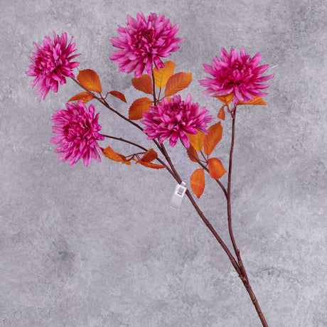 A spray of bright pink, faux chrysanthemum flowers with orange-red leaves
