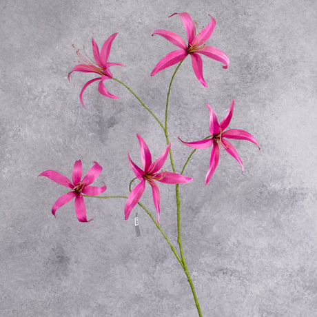 A tall. faux lily spray with bright pink flowers