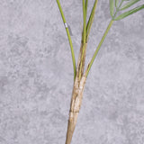 A close up of the main stem of a faux palm bush as it branches into three fronds