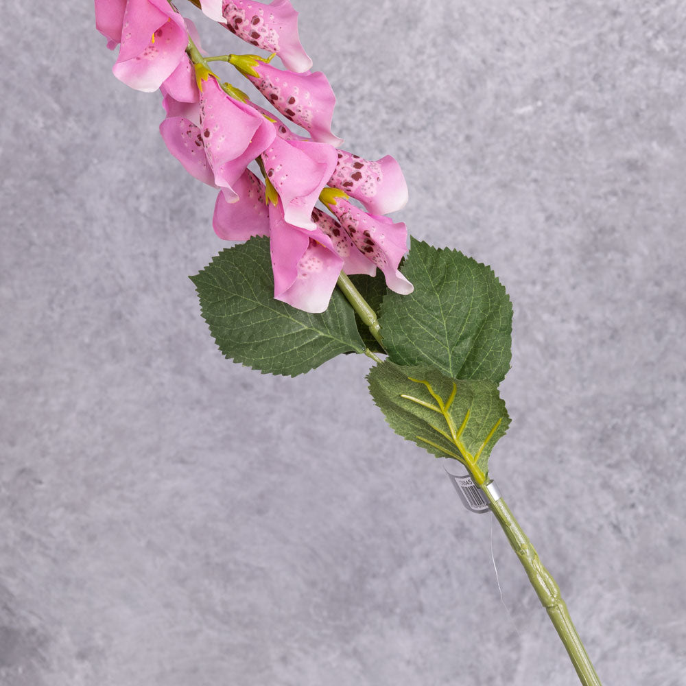 A single faux, pink foxglove stem close up