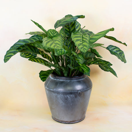 A faux plant in a grey pot