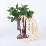 Bleached white amaranthus displayed in a rustic urn with some faux bay leaf stems.