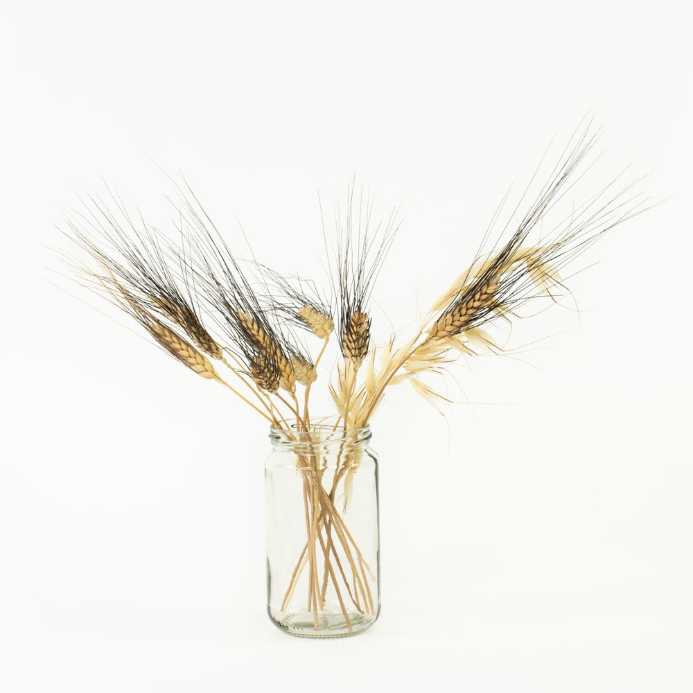 A 370ml glass jam jar with containing some dried flowers