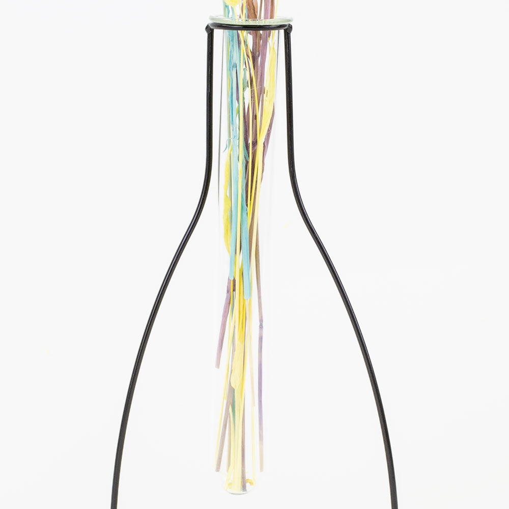 a metal framed, shaped outline of a vase that contains a glass test tube, in which to place flowers