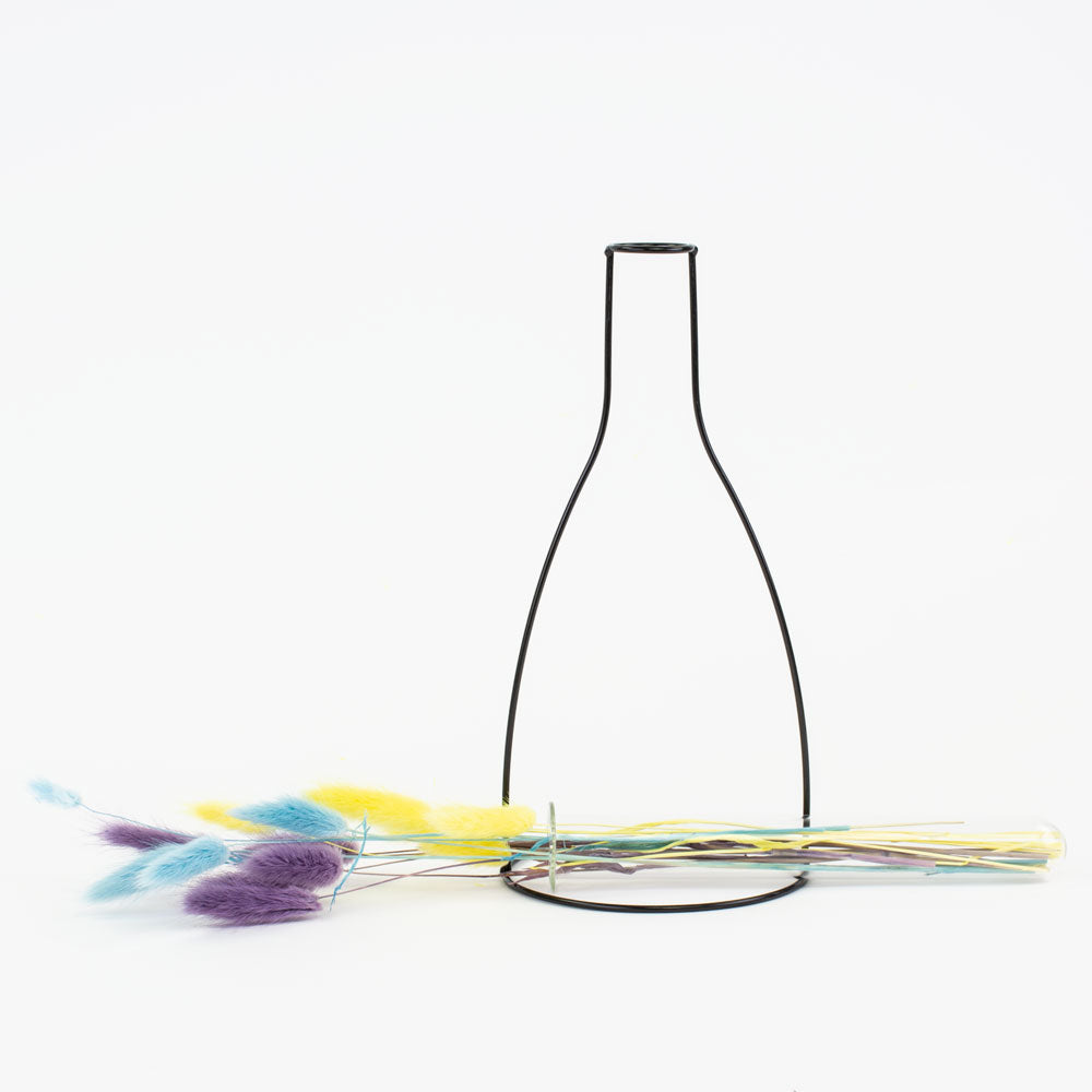 a metal framed, shaped outline of a vase that contains a glass test tube, in which to place flowers