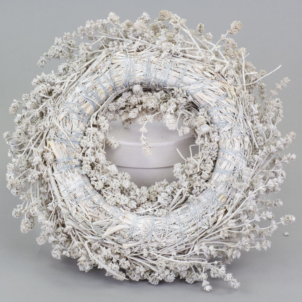 a wreath made of linen herb and painted a chalky white colour, against a white background