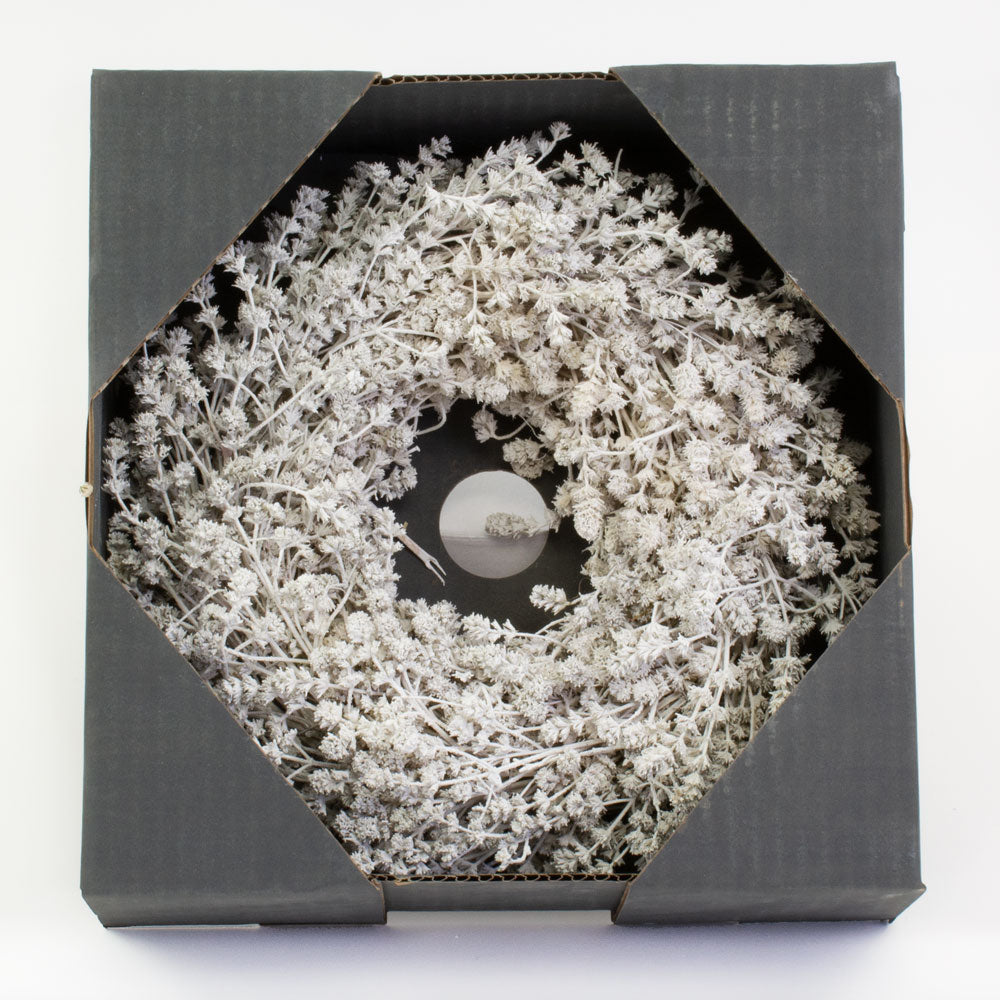 a wreath made of linen herb and painted a chalky white colour, against a white background