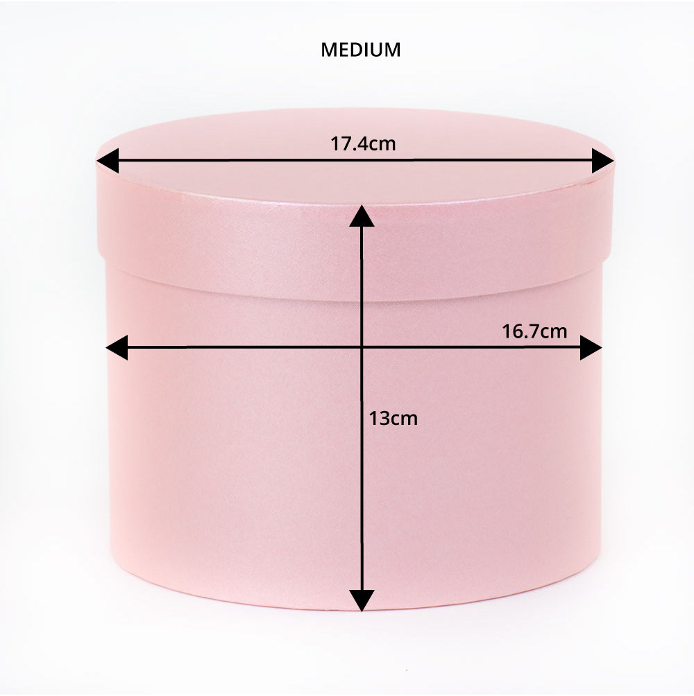 a medium, pale pink hat box with dimensions marked on the image