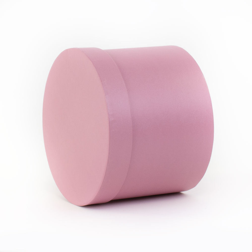 a baby pink coloured hat box on its side in three quarter aspect