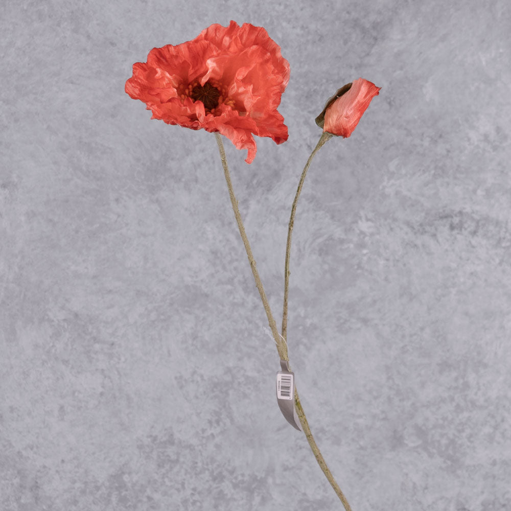A faux poppy stem, with a flower and bud in a delicate reddish orange colour.