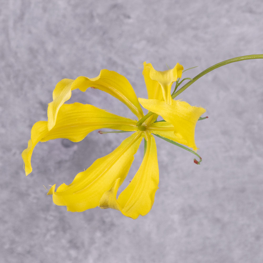 A close up of a faux gloriosa with a yellow flower